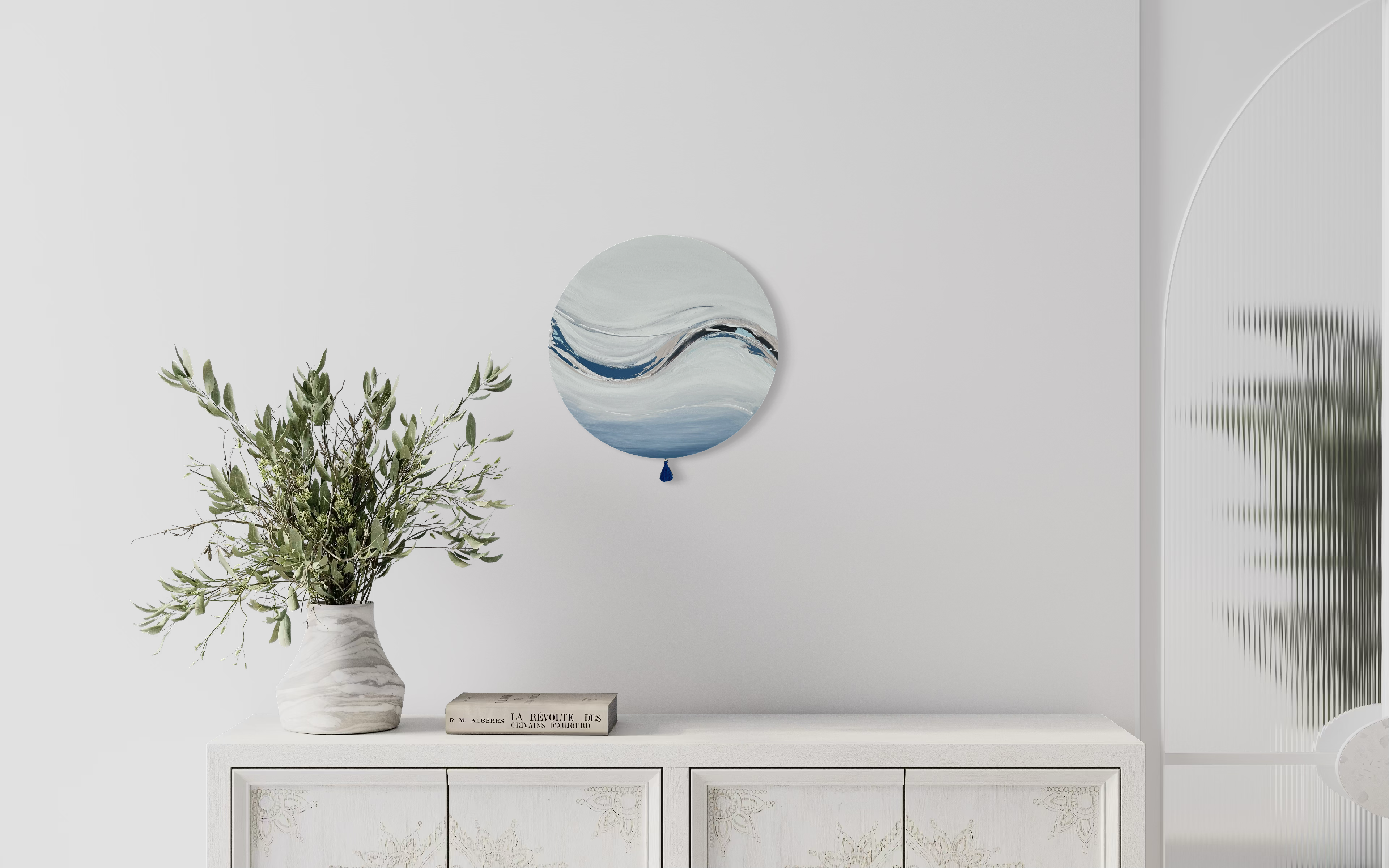 Das Kunstwerk "Cold clarity". Moderne Wabi Sabi Kunst mit daoistischer Seele von Nadine Elsner. 40cm im Durchmesser. Weiche blau und weiß Töne mit weichem Kunstleder. Sanfter Abschluss mit einer kleinen blauen Quaste. Das Bild bringt sehr viel Klarheit und Raum zum Atmen in einen schönen, hellen Raum.