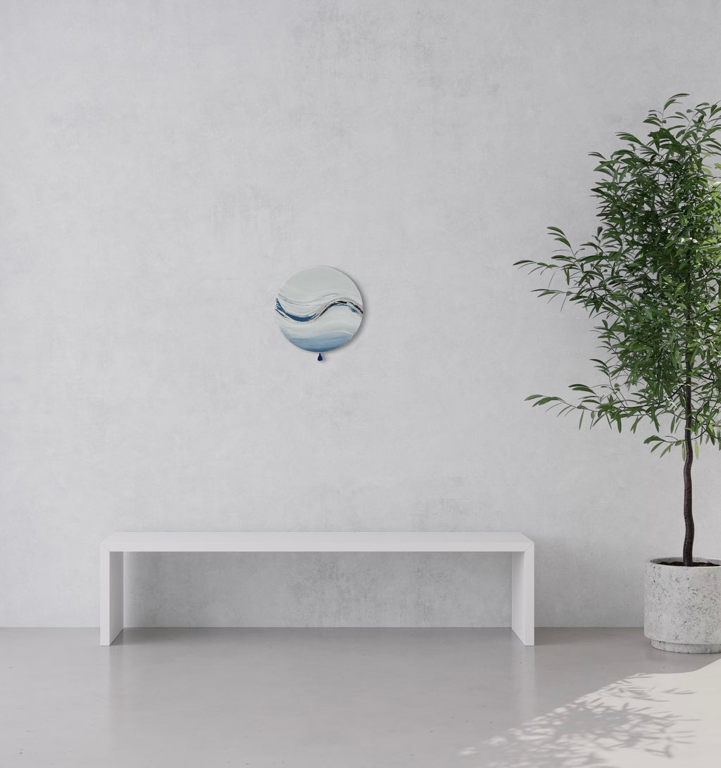Das Kunstwerk "Cold clarity". Moderne Wabi Sabi Kunst mit daoistischer Seele von Nadine Elsner. 40cm im Durchmesser. Weiche und kühlende weiß und blau Töne mit weichem Kunstleder. Sanfter Abschluss mit einer kleinen blauen Quaste. Das Bild bringt eine kühlende, sehr sanfte und offene Atmosphäre in einen sehr hellen, offenen Raum.