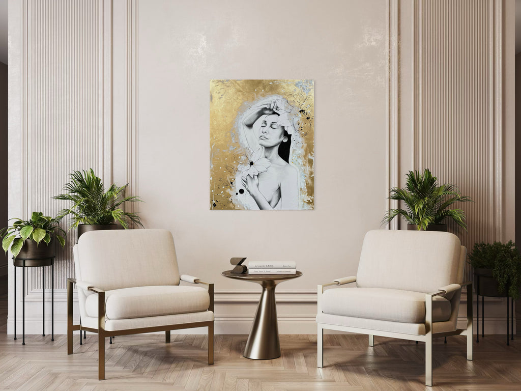 Das Kunstwerk hängt an einer beigen Wand. Rechts und links stehen 2 sehr gemütliche moderne Sessel. In der Mitte ein goldener moderner Tisch. Überall stehen Pflanzen. Alles harmoniert farblich miteinander.