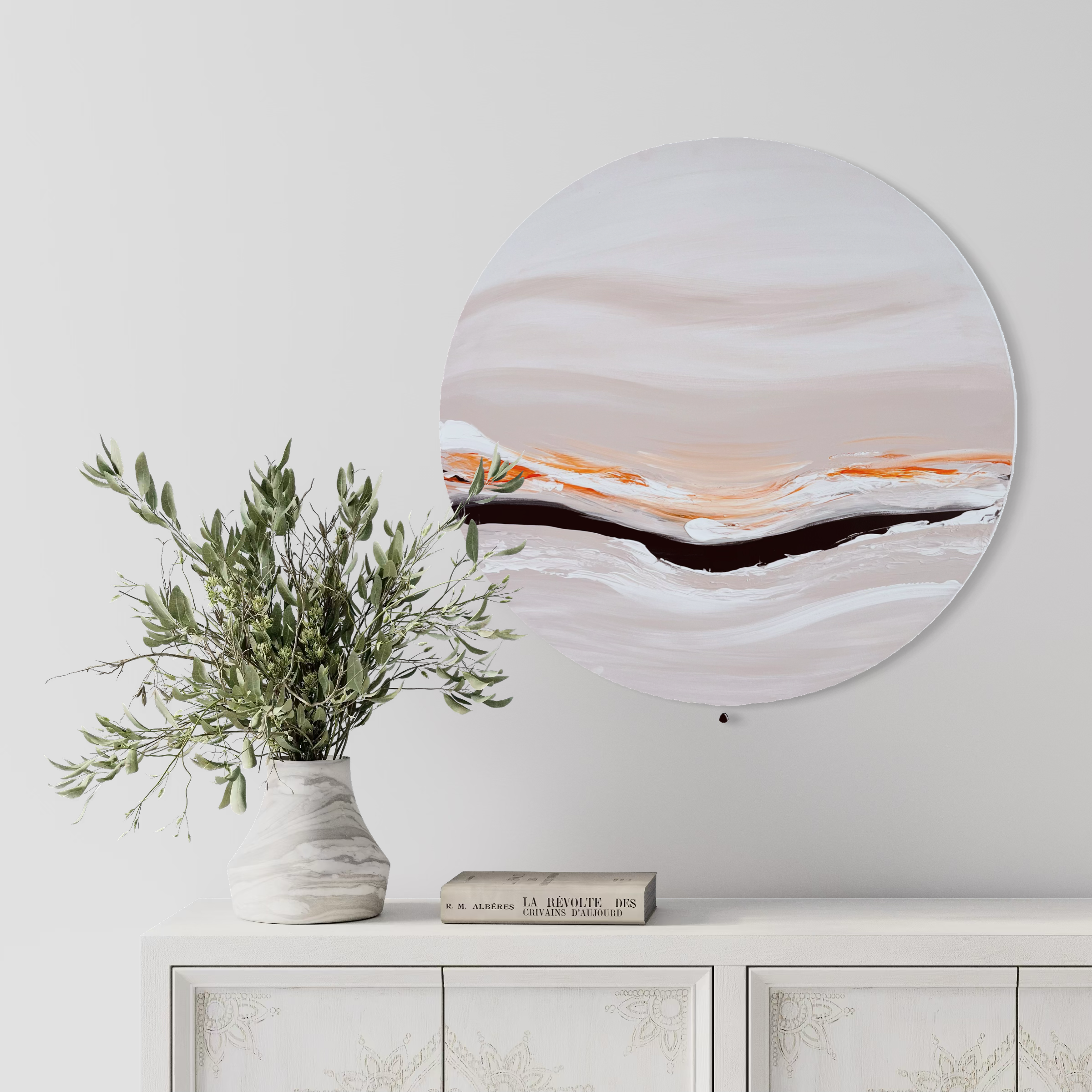 Kunstwerk energizing sun Nadine Elsner modern Wabi Sabi Art. Das Werk hängt über einen verzierten weißen Kommode. Auf der Kommode sind eine Vase in Marmoroptik mit einer Eukalyptuspflanze und ein Buch.