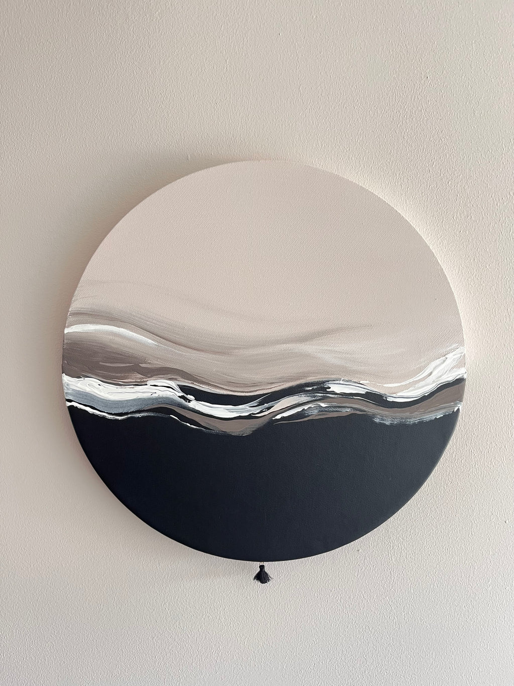 Das Kunstwerk "Gentle Touch". Der untere Teil der Leinwand ist überzogen mit weichem, schwarzen Kunstleder. Die Oberkante, welche in der Mitte der Leinwand liegt ist wellenförmig geschnitten. Dickere Spachtelaufträge in weiß, dunklerem und hellerem nude Ton gehen sanft mit den Linien mit. Mal gebrochen, mal mit einem schönen Verlauf. Der obere Teil der Leinwand ist in einem hellem nude Ton gehalten und verläuft zur Mitte langsam in den dunkleren nude Ton.