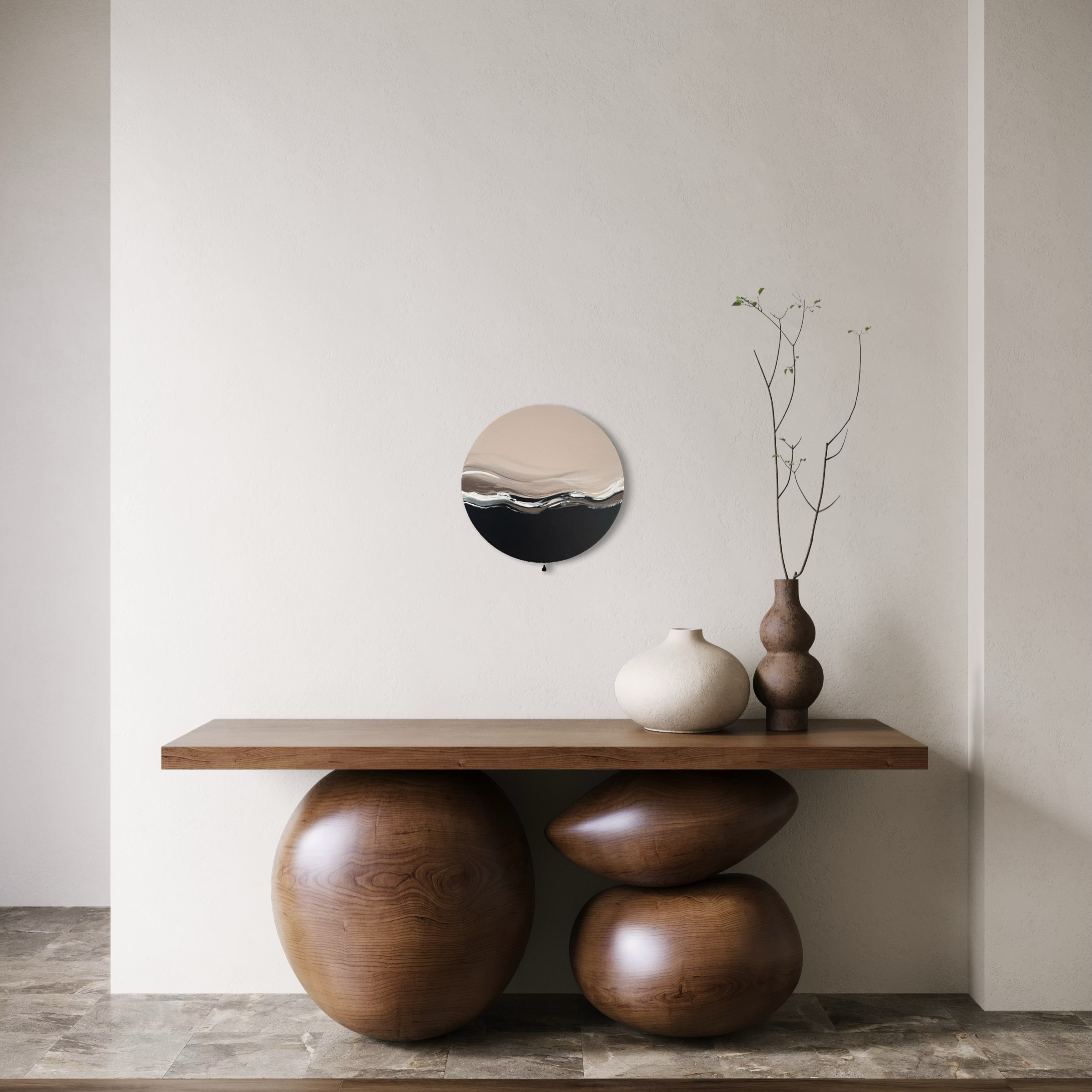 Das Werk hängt über einem modernen Holzsideboard. Die Füße des Regals haben die Optik großer Stein, auf denen es liegt, aber auch in der gleichen dunklen Holzoptik. Darauf stehen natürliche Keramikvasen. Das Bild ergänzt in seiner Form und der kleinen Quaste wunderbar die besondere und sehr ruhige Stimmung.