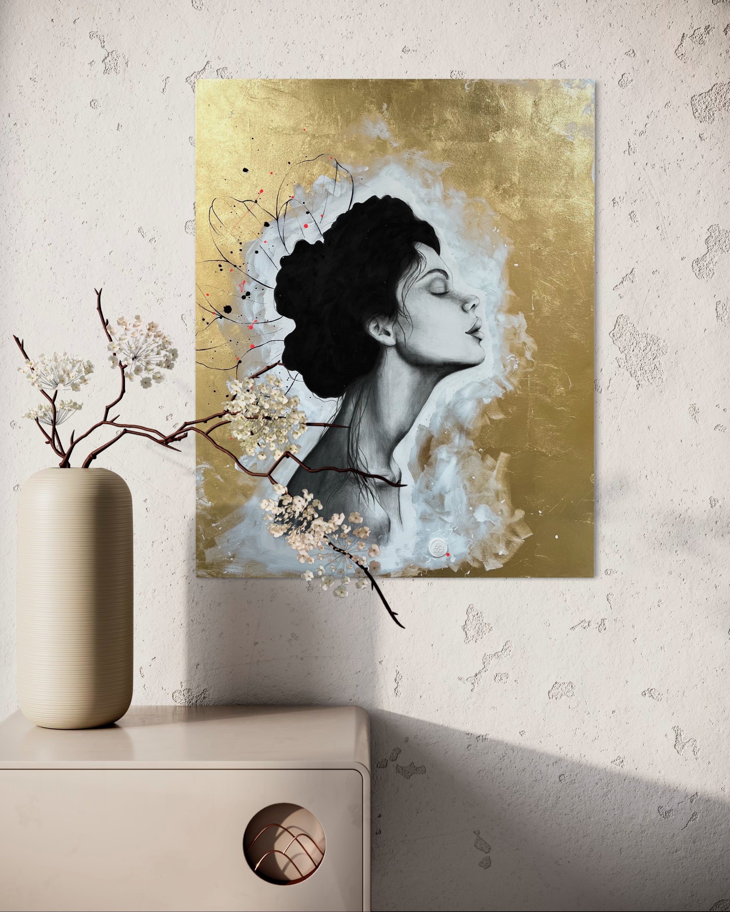 Das Werk hängt an einer Wand, die eine natürlich Struktur in beiger Farbe hat. Schräg unter dem Bild steht einer im nude Ton farbene Kommode mit einer nude farbenen Vase. Kirschblüten hängen vor dem Bild, was sehr schön zur Stimmung passt.