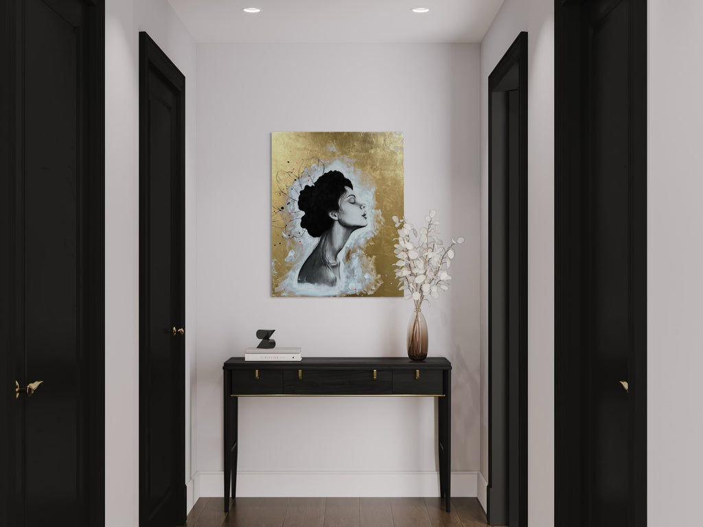 Das Werk hängt am Ende eines hellen Flures über einem schwarzen Tischchen. 