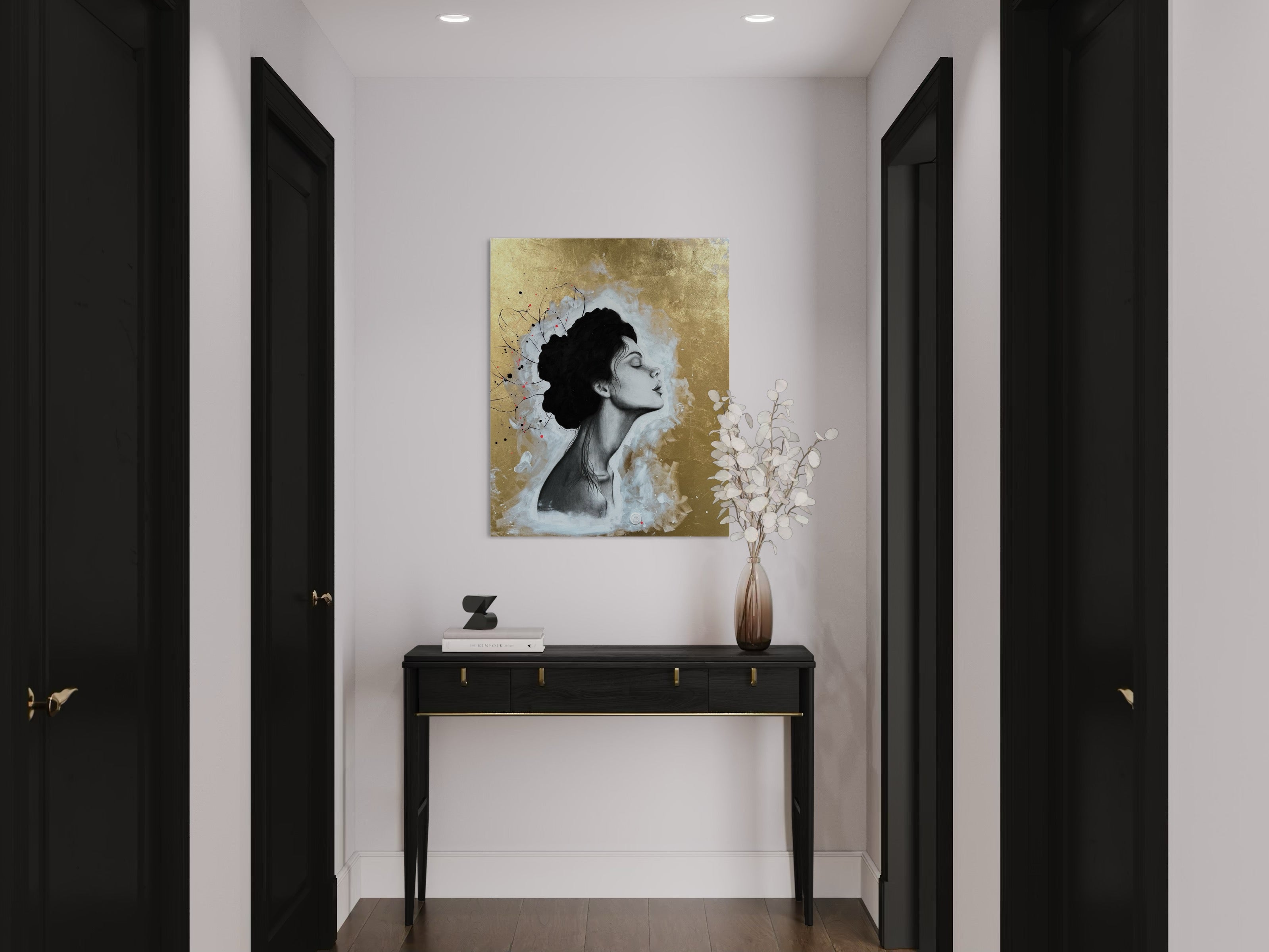 Das Werk hängt am Ende eines hellen Flures über einem schwarzen Tischchen. 