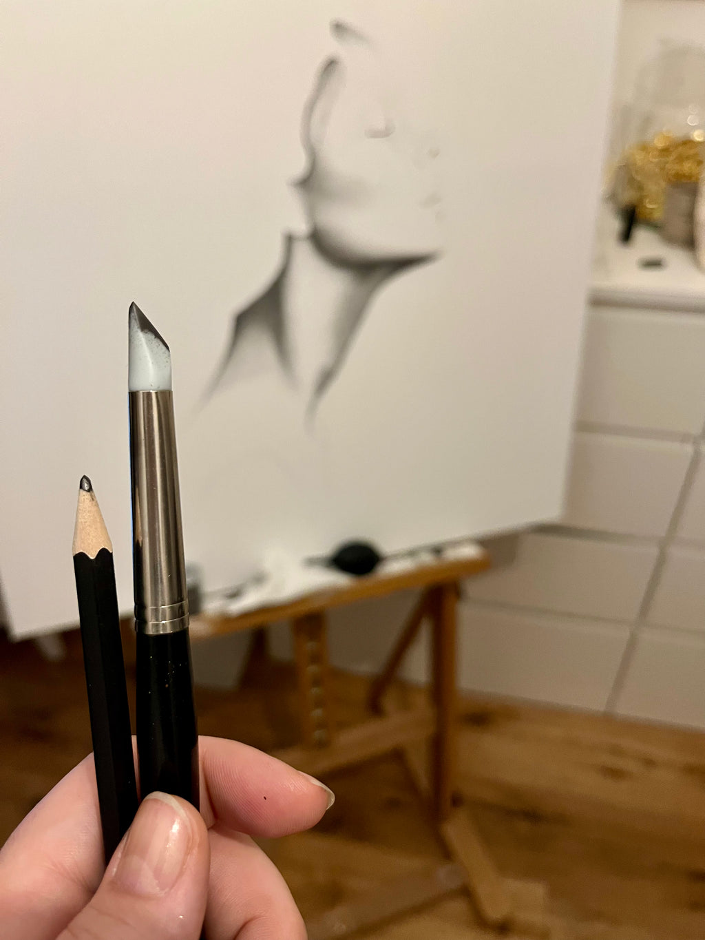 Detailaufnahme des Werkes im Atelier. Im Vordergrund die Arbeitsmaterialien. Ein Gummipinsel und ein Bleistift.