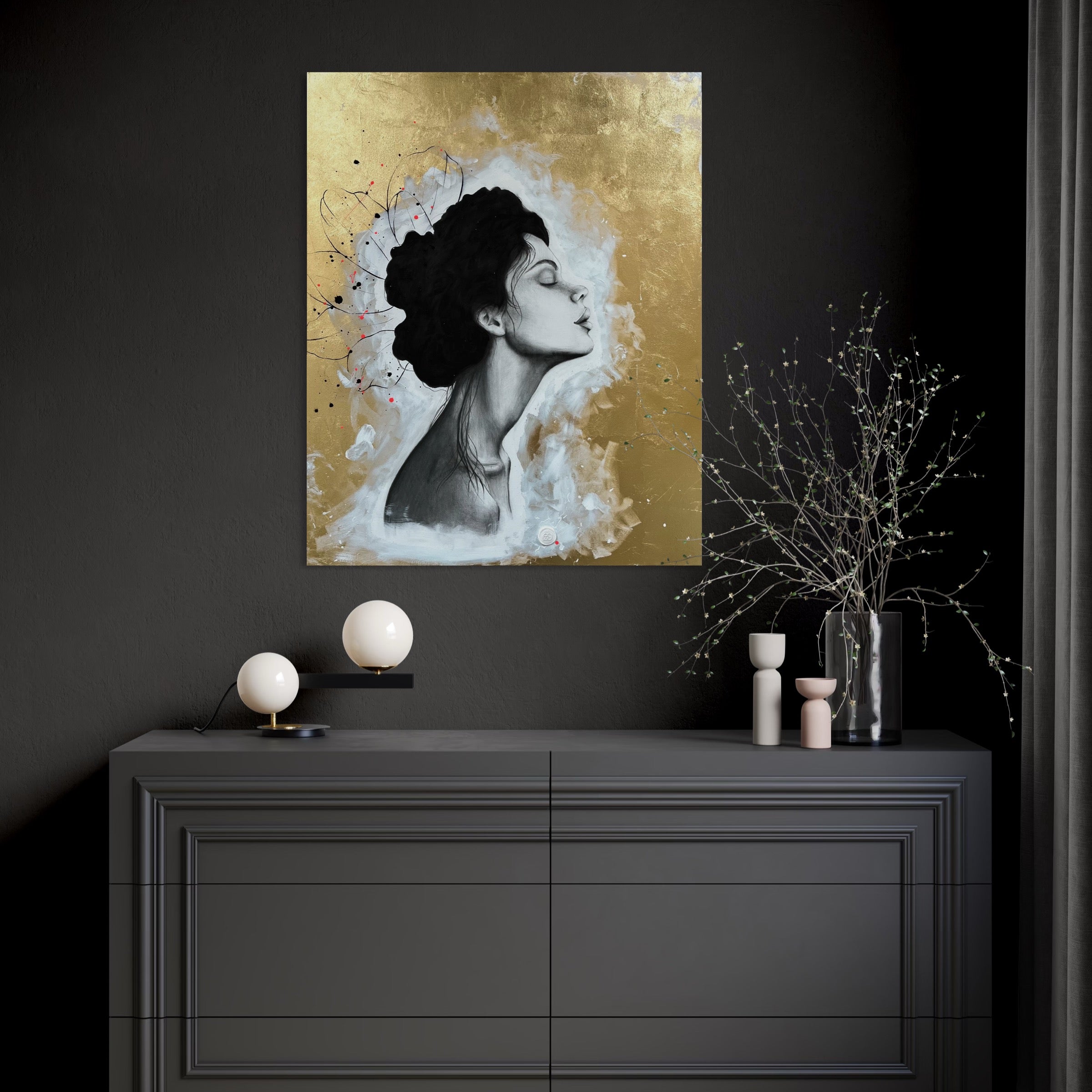 Das Werk hängt in einem modern dunkel gehaltenen Raum über einer dunklen Kommode. Auf der Kommode gibt es Deko mit hellen und goldenen Akzenten.