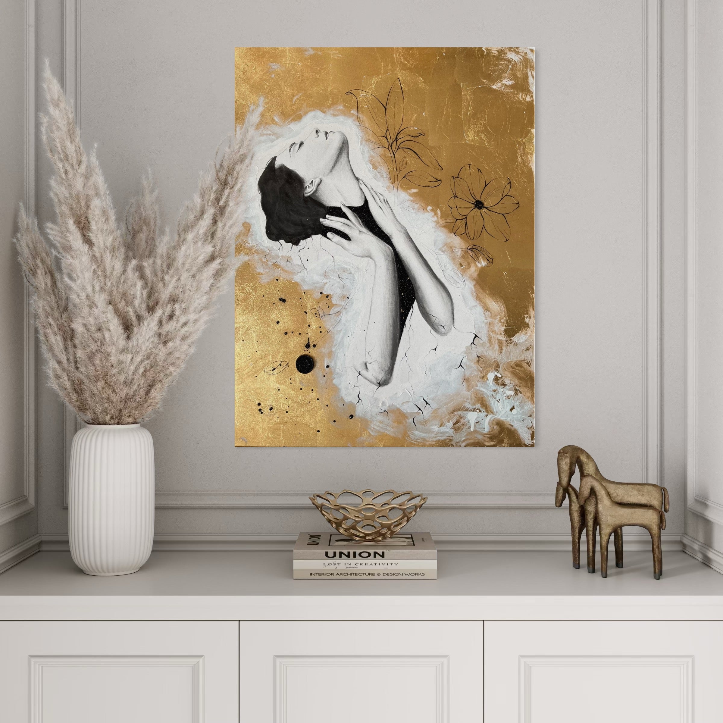 Kunstwerk roots Nadine Elsner Art. Das Bild hängt in einer hellen Nische über einer Kommode. Es gibt einen wunderschönen Kontrast zur hellen Farbgebung. Auf der Kommode stehen weiße und goldene Deko.