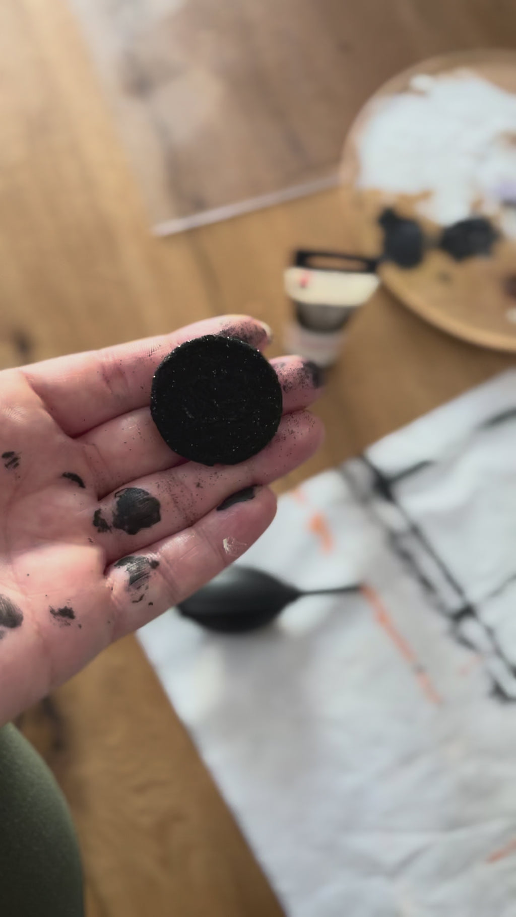 Video Detailaufnahme aus dem Atelier. Nadine hält ihr Logosigel in schwarz in der Hand.